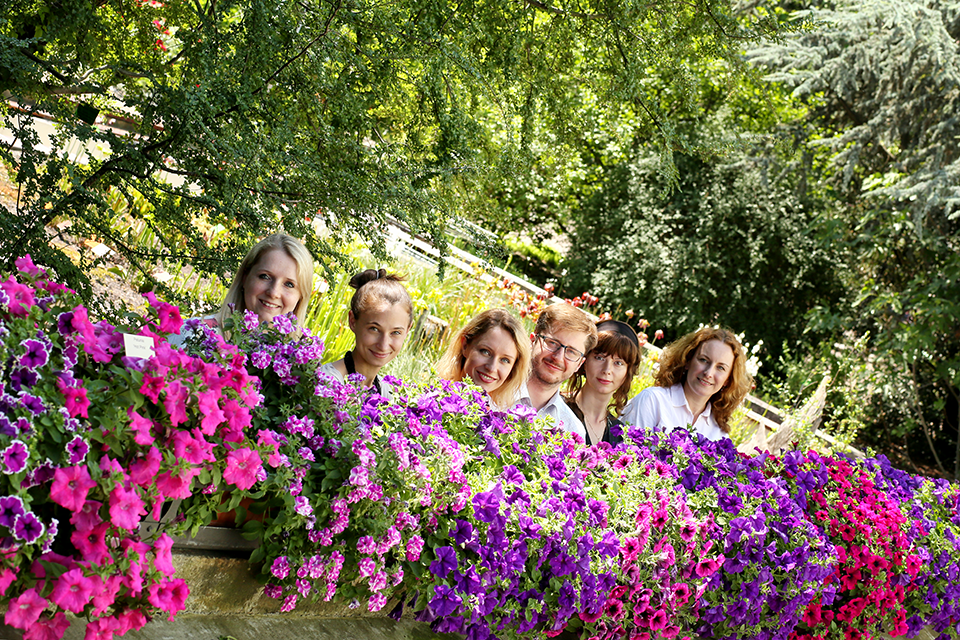 akademicy - fotografia grupowa w parku wśród kwiatów i drzew